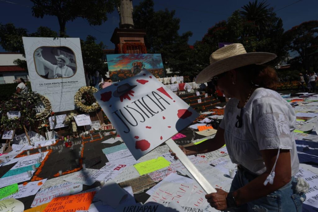 Mujer dejando letrerode justicia tras marcha en Uruapan
