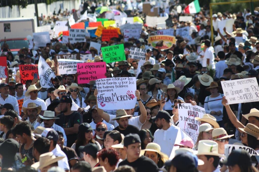 Población con pancartas marchando en Uruapan